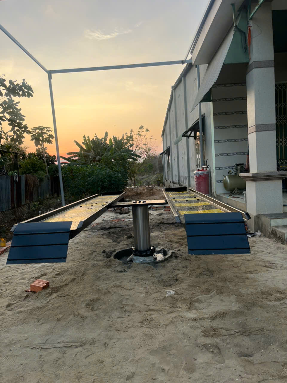 Thợ rửa xe thao tác trên cầu nâng 1 trụ âm nền